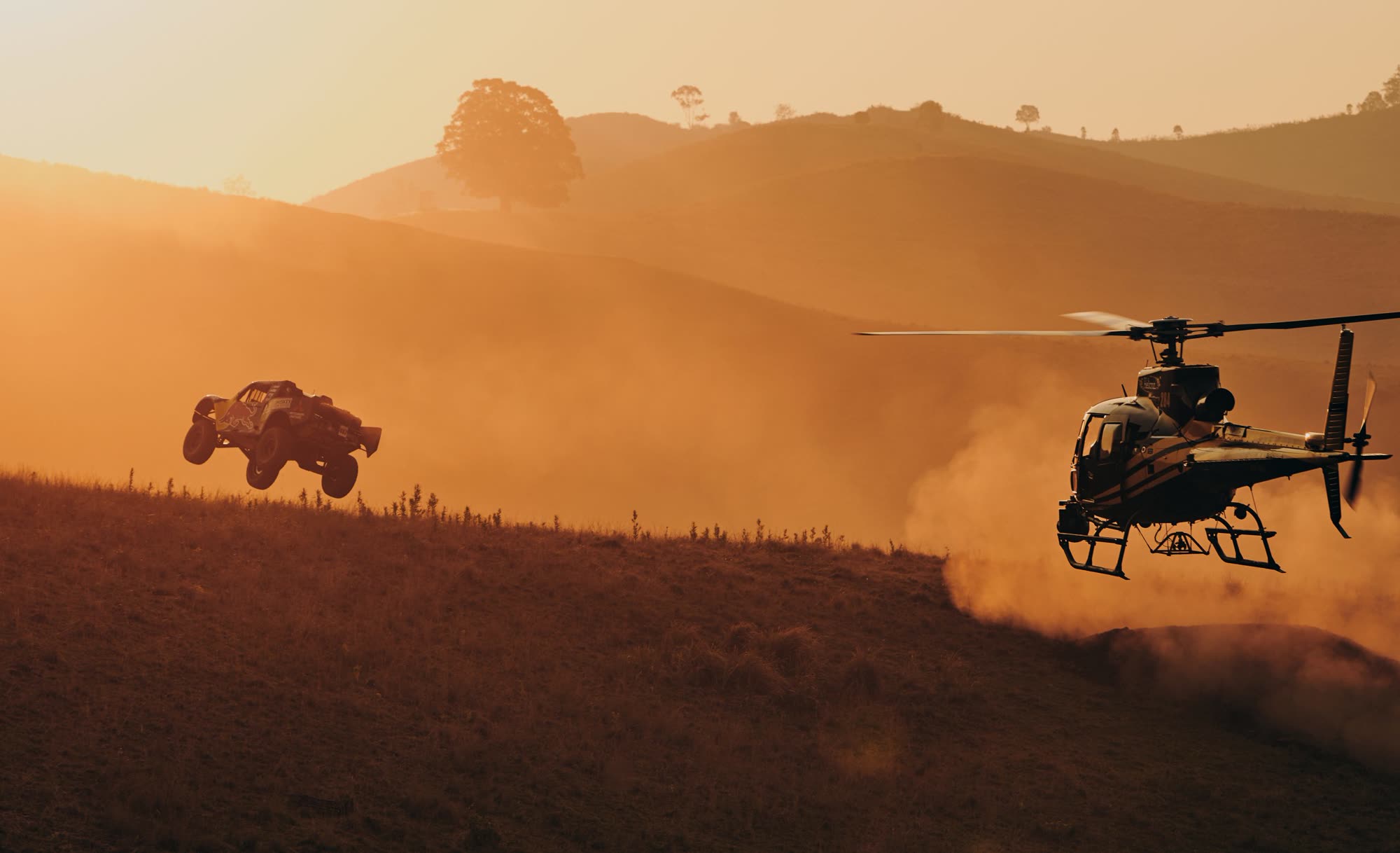 Helicopter camera ship tracking off-road racer Toby Price across the desert at golden hour
