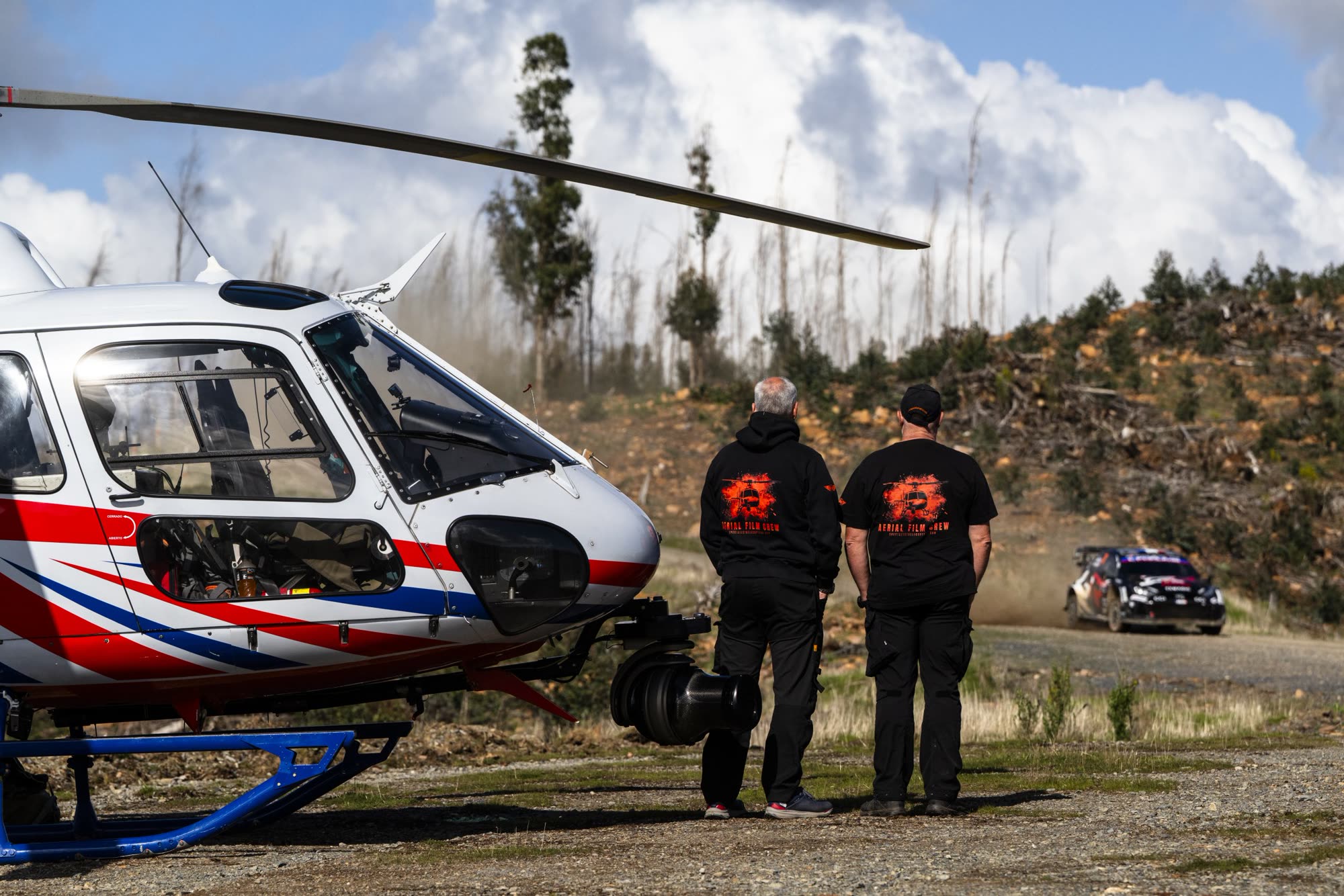 Chief pilot David Adamson with broadcast crew beside the helicopter at WRC
